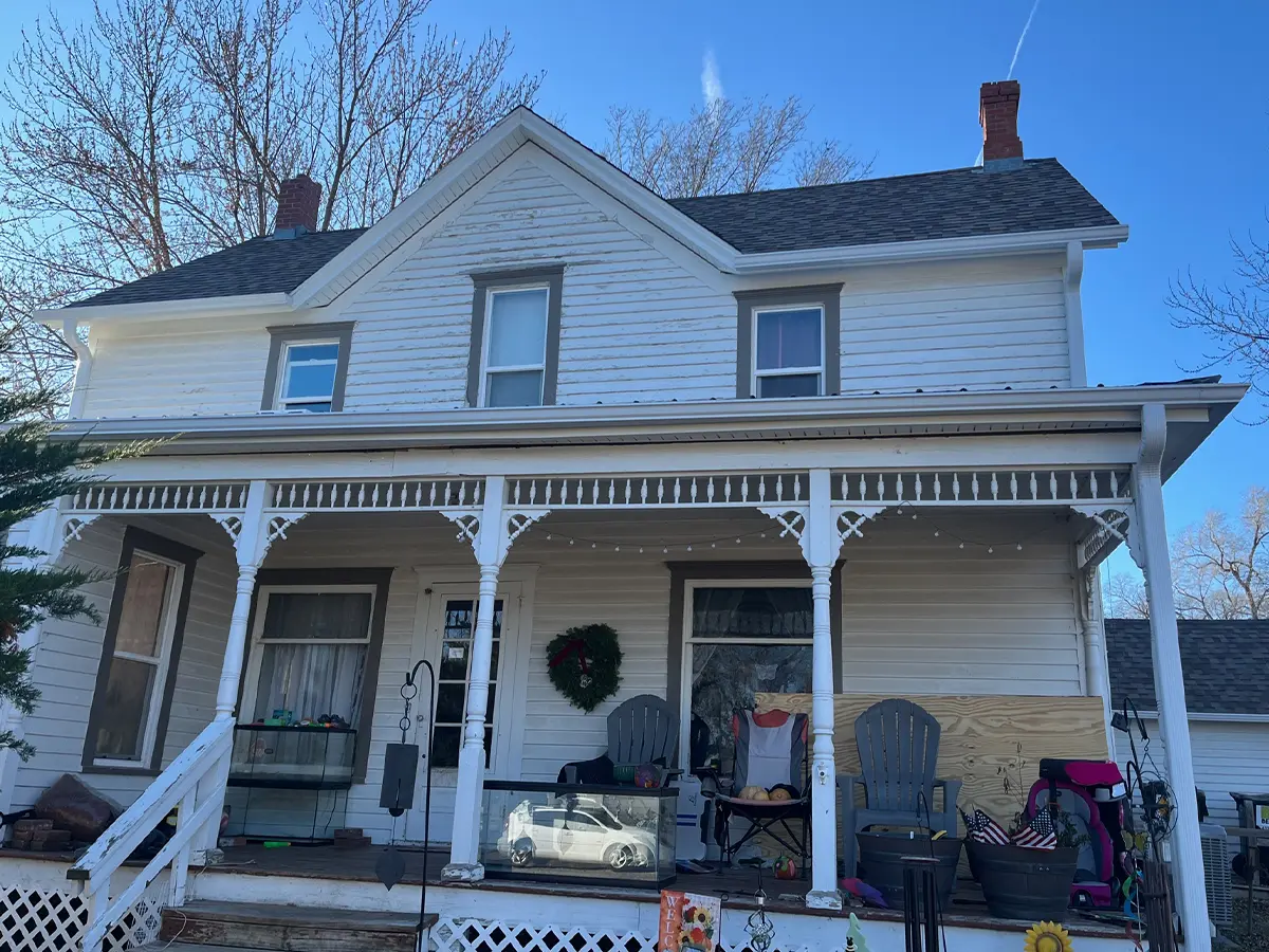 Beautifully restored two-story vintage home with updated porch details and a tidy front yard, showing off architectural charm